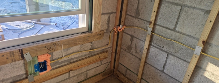 Pre-drywall inspection showing electrical wiring, nail plates, window framing, and furring strips inside a new construction home in Central Florida.