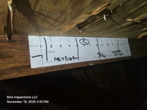Wind mitigation inspection showing roof deck nailing pattern measured with a shiner gauge in a Central Florida attic.